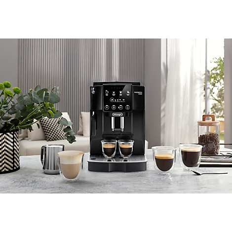 Schwarzer Kaffeevollautomat, zwei Gläser Espresso, Kaffeebohnen und Kaffeegläser auf Tisch.