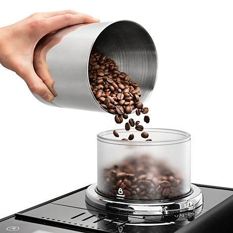 Hand hält metallenen Behälter, aus dem Kaffeebohnen in einen durchsichtigen Behälter fließen. Teil einer Kaffeemaschine.