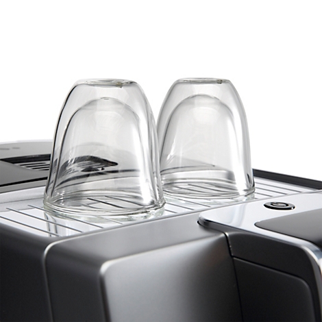 Deux verres retournés sur une machine à café. Le métal argenté contraste avec le blanc de l'arrière-plan.