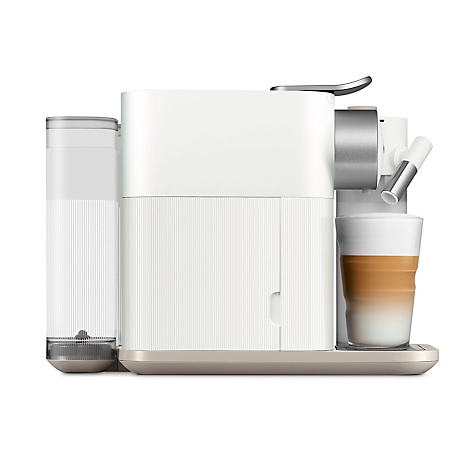 Een crèmewitte koffiemachine met een glas latte macchiato. Het ontwerp is modern en minimalistisch.