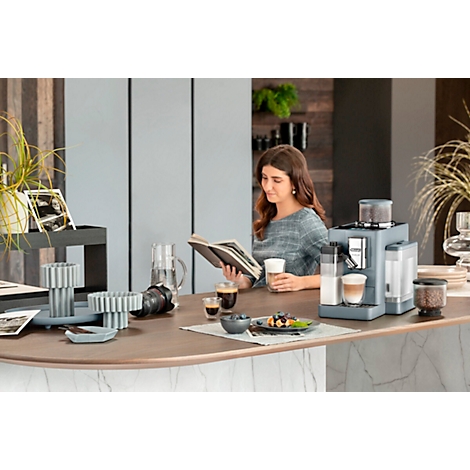 Vrouw leest boek aan de balie, koffiemachine, kopjes, koffie, snacks. Stemming: ontspannen.