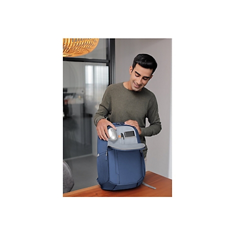 Ein Mann Ã¶ffnet einen blauen Rucksack und lÃ¤chelt, er hÃ¤lt eine Taschenlampe in der Hand.