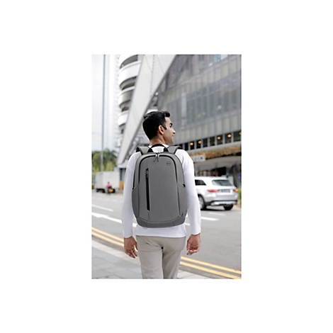 Ein Mann mit grauen Rucksack geht auf einer StraÃŸe entlang. Im Hintergrund: GebÃ¤ude, Autos.