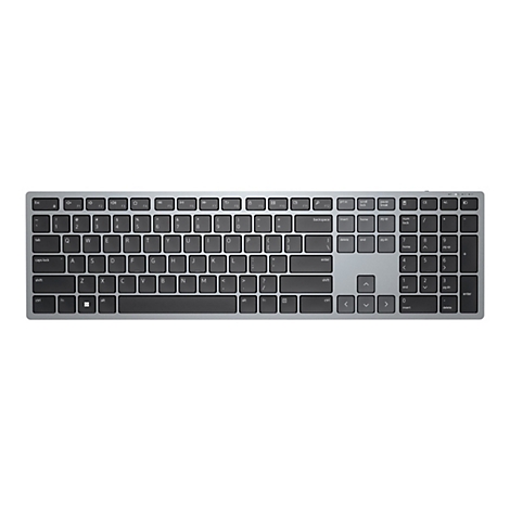 Vue de dessus d'un clavier argenté avec des touches noires, placé sur un fond blanc.