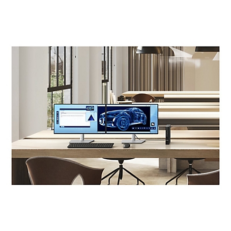 Un grand écran avec deux vues, l'une affichant une ébauche de conception automobile, l'autre une interface utilisateur. Sur la table se trouvent une souris, un clavier et un ordinateur.