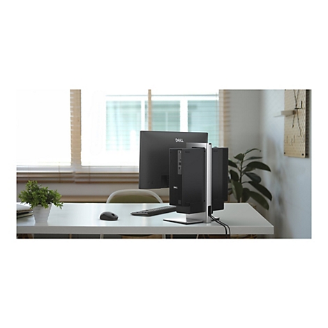 Schreibtisch mit Dell-Monitor, PC-Gehäuse und Zubehör. Fenster und Wand mit Dekoration im Hintergrund.