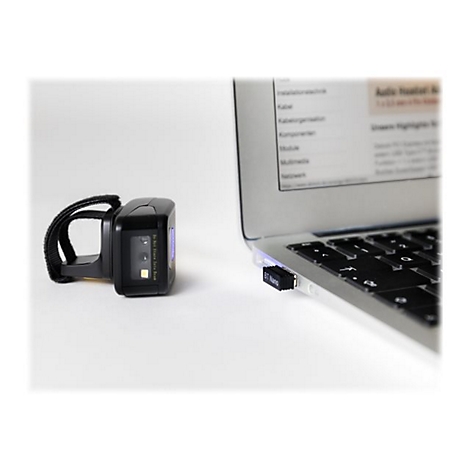 Ein schwarzer Barcode-Scanner mit Armband neben einem Laptop mit eingestecktem Bluetooth-Adapter.