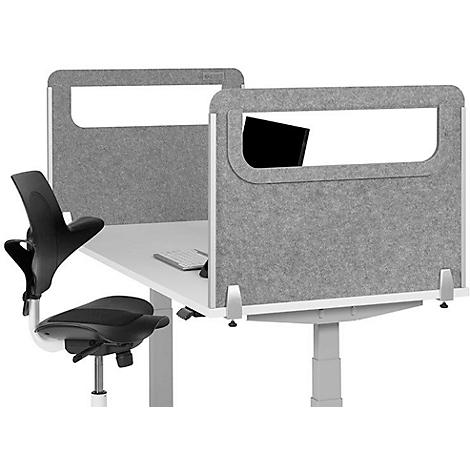 Grey desk divider with rectangular cutouts; behind desk with keyboard and chair.