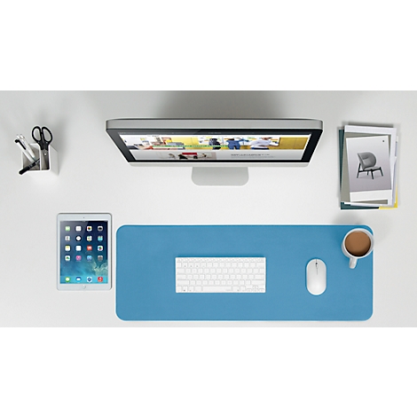 Top view of a desk featuring a screen, tablet, keyboard, mouse, coffee cup, and pen holder.