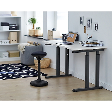 A height-adjustable desk with a laptop and chair in a bright office. On the table are folders and office supplies.