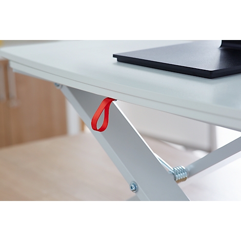 Close-up of a white desk with a red loop. The desk has a black rectangle on its surface and a silver metal construction.