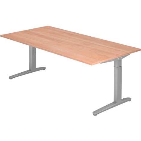 A rectangular, height-adjustable desk in wood look. The legs are silver.
