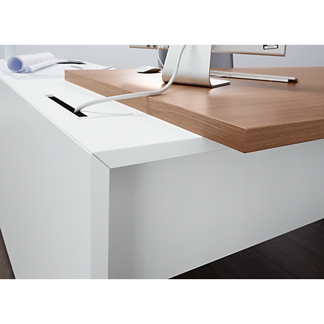 Close-up of a white desk with a brown wooden top. A cable is being fed into an opening.
