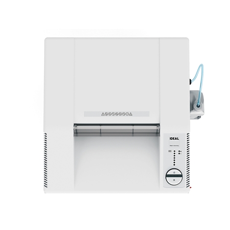 Vue de dessus d'une machine blanche avec des panneaux de commande, des inscriptions et un tube bleu.