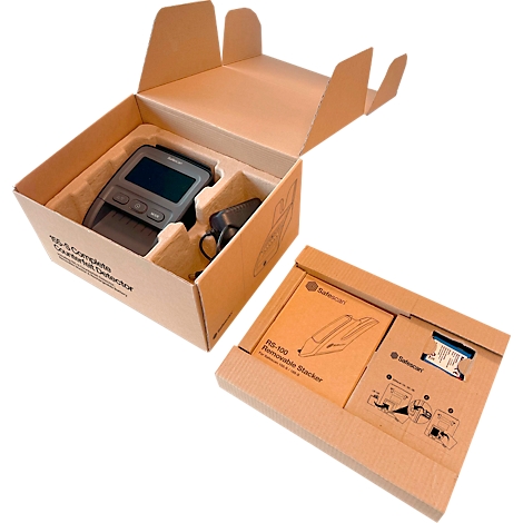 Boîte ouverte avec vérificateur de billets, alimentation et accessoires. À côté se trouve une autre boîte ouverte avec des accessoires.