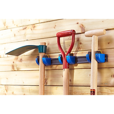 Three garden tools, a hoe, a spade and a shovel, are hanging on a wooden panel wall.