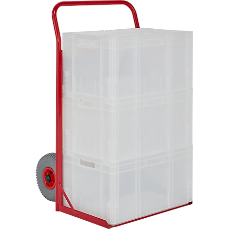 Chariot à bras rouge avec des boîtes en plastique, entièrement chargé.