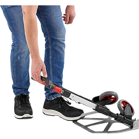 Personne en jean bleu actionne un appareil de mesure à roulettes.