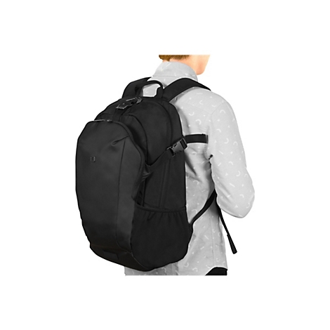Eine Person, die einen schwarzen Rucksack auf dem RÃ¼cken trÃ¤gt, steht vor weiÃŸem Hintergrund. Der Rucksack hat mehrere FÃ¤cher und Gurte.