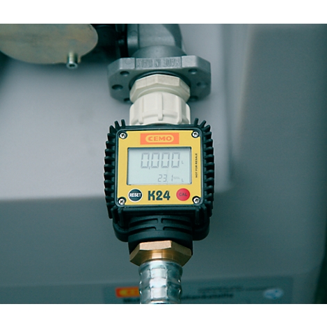 Close-up of a yellow flow meter with digital display: 0.000 and K24. The connection to a metallic part is shown.