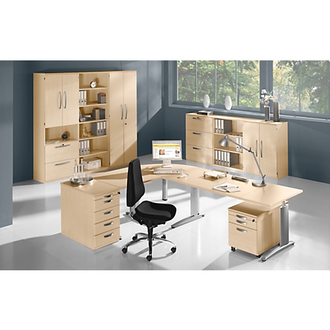 A bright office with wooden furniture, a desk, a chair and a window with daylight. File folders are on cabinets.