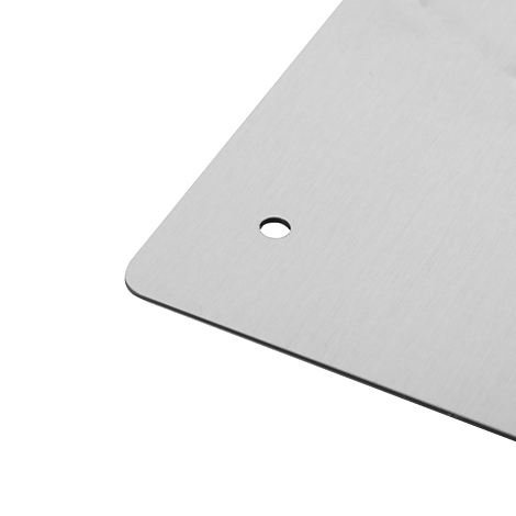 Nahaufnahme einer gebürsteten Aluminiumplatte mit einer Ecke und einem kreisrunden Bohrloch.
