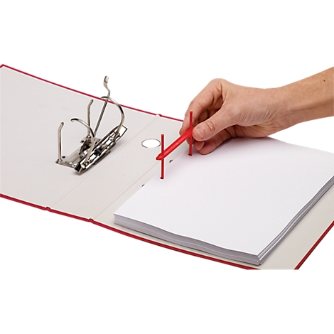 Red open binder with paper stack. Hand holding red tool for filing.