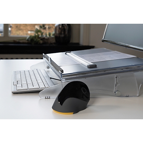 A white desk displays a keyboard, mouse, and paper. Windows and a vase are visible in the background.