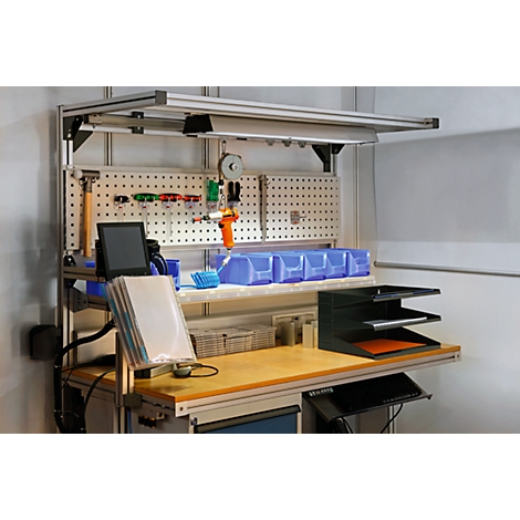 Workbench with tools, shelf and lighting. Hammers, wrenches, pliers hang on the pegboard. Blue drawers and a tablet.