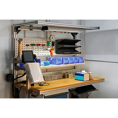 Workbench with pegboard, tools, drawers, and a lamp.