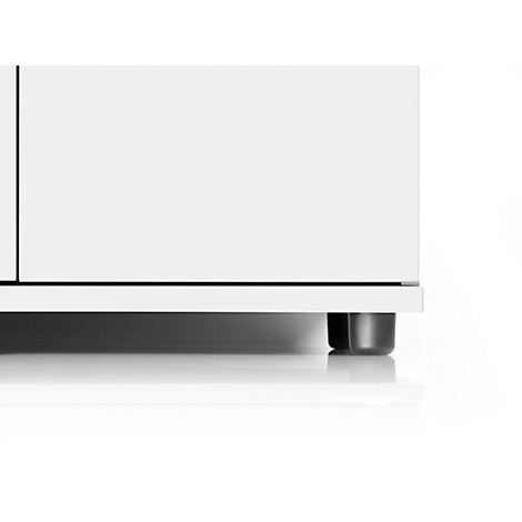 Close-up van een witte kast. Zwarte poten en een zwarte lijn onderstrepen het design. Schaduwen op een witte achtergrond.