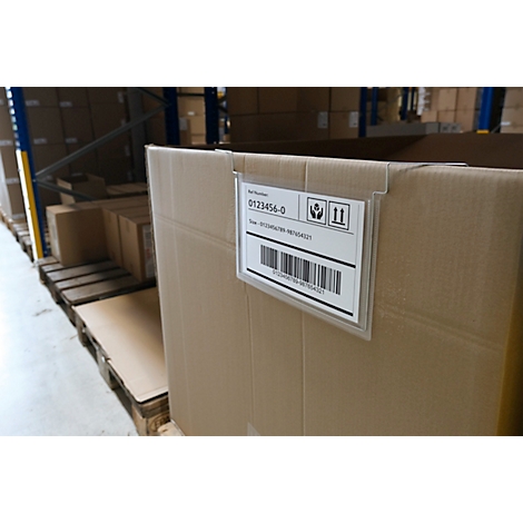Nahaufnahme einer Kartonverpackung mit Etikett und Barcode. Im Hintergrund Lagerregale.