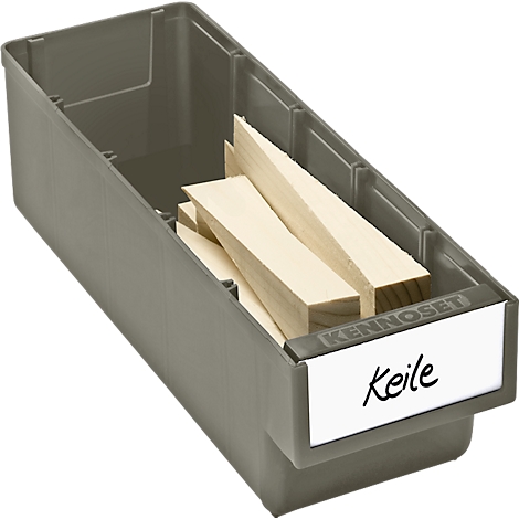 Gray plastic box containing wooden wedges. A handwritten sign reads "Keile".