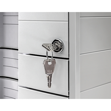 Key in the lock of a cabinet, gray metal doors, detail view.
