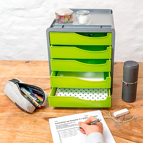 Green drawer cabinet with pens, accessories and a person filling out a form at a desk.