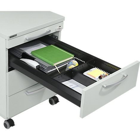 Opened gray drawer filled with office supplies like notepad, mouse, paper, sticky notes, and tape.