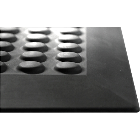 Close-up of a black rectangular mat with raised, rounded studs. The mat has a raised edge.