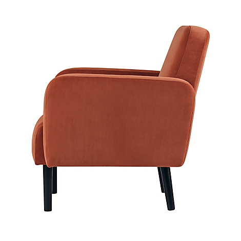 Zijaanzicht van een roestkleurige fluwelen fauteuil met zwarte poten.