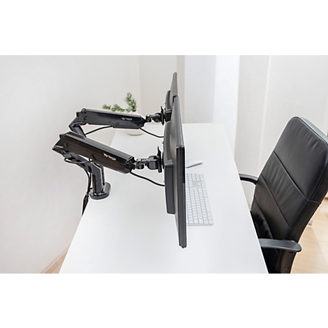 Twee monitoren op een bureau, vastgehouden door zwarte, verstelbare beugels. Op de achtergrond een zwarte bureaustoel.