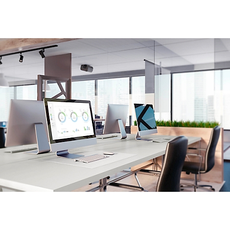 Office with computers on a desk. Charts are visible on the monitor.