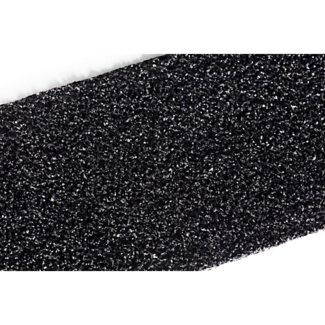 Close-up detail of a black, textured material with white, shiny particles.