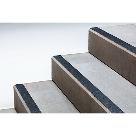 Grey stone steps with non-slip black strips on the edges.