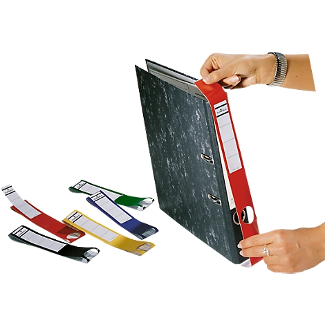 A person holding a red binder with paper labels. Colored labels in red, yellow, green, blue and black are on the table.