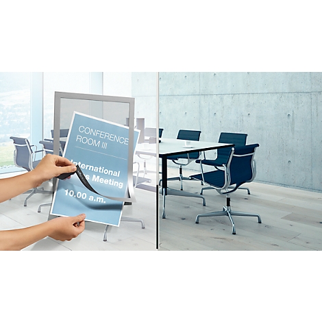Hands holding a poster with the inscription 'Conference Room'. On the right: conference table with chairs.