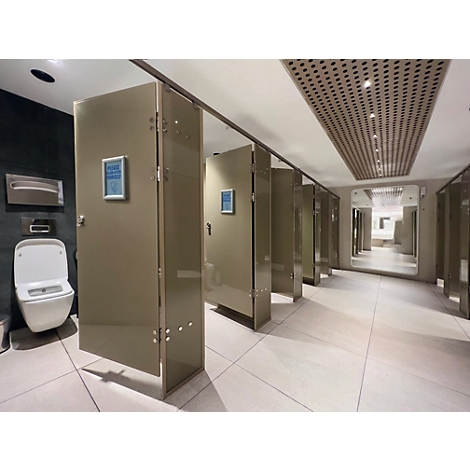 Rij moderne toiletcabines met glanzende beige deuren in een licht betegelde, hoogwaardige toiletruimte.