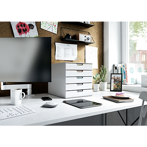 Wit bureau met lade-element, monitor, tablet en decor. Notities hangen op het prikbord.
