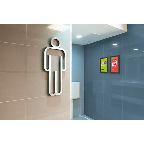 Männer-Toilettenschild aus Metall an einer beigefarbenen Fliesenwand neben einem blau gefliesten Innenraum.