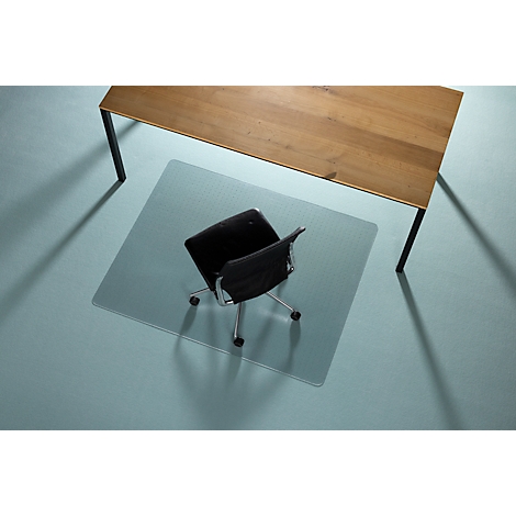 Bureaustoel op transparante vloerbeschermingsmat onder een houten tafel. Op een lichte vloer, vanuit vogelperspectief.