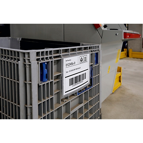 Grijze plastic container met label: artikelnummer, barcode. Blauwe houders. Achtergrond: magazijn.