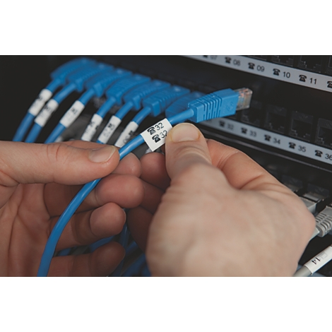 Hände halten ein blaues Netzwerkkabel mit einem Etikett, das ein Telefonsymbol und die Zahl 32 zeigt.